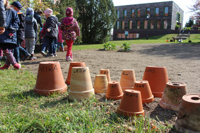 Einige Kinder haben einen Tontopf mitgebracht, der später mit Sand befüllt wird und dann ebenfalls im Boden nistende Bienen und Hummeln anlockt. Foto: FNR/N. Paul